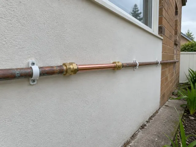 Repaired copper water pipe fixed to an exterior rendered wall in Dee Why